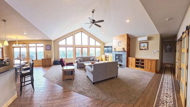 living area featuring hardwood / wood-style flooring, high vaulted ceiling, a fireplace, and a wall mounted AC