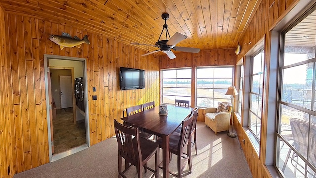 carpeted dining area featuring washer / clothes dryer, wooden walls, wood ceiling, and a ceiling fan