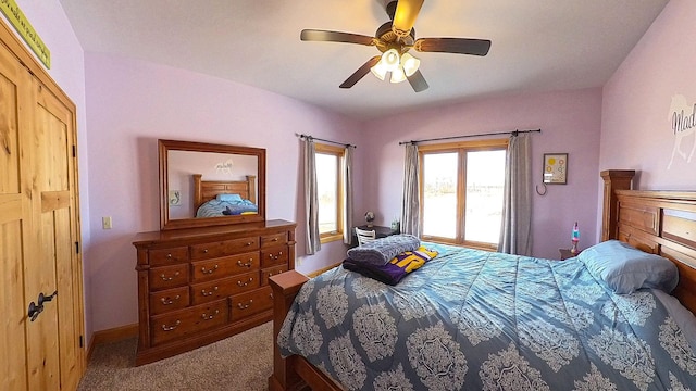 carpeted bedroom with baseboards and a ceiling fan