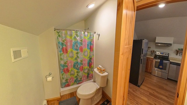 bathroom featuring lofted ceiling, a shower with curtain, wood finished floors, and toilet