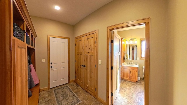 interior space with stone finish floor, baseboards, and a sink