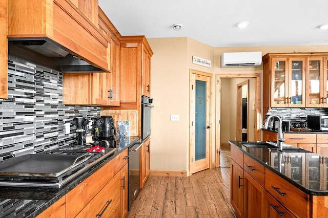 1036 Ziebarth Rd, Wrenshall, MN 55797 - kitchen featuring custom exhaust hood, a sink, a wall unit AC, appliances with stainless steel finishes, and light wood-type flooring