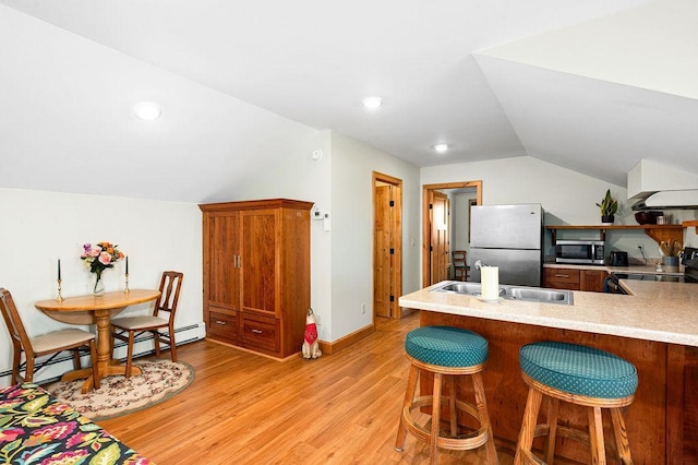 1036 Ziebarth Rd, Wrenshall, MN 55797 - kitchen with stainless steel appliances, lofted ceiling, light wood-style flooring, a breakfast bar area, and a sink