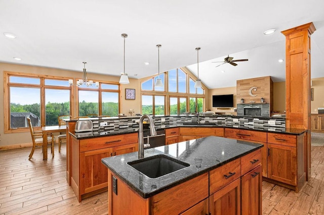 1036 Ziebarth Rd, Wrenshall, MN 55797 - kitchen featuring a center island with sink, ceiling fan, decorative backsplash, light wood finished floors, and vaulted ceiling