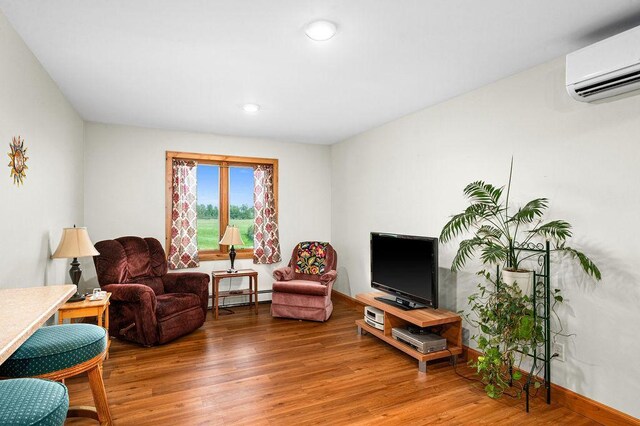1036 Ziebarth Rd, Wrenshall, MN 55797 - living area featuring a wall mounted AC, a baseboard heating unit, wood finished floors, and recessed lighting