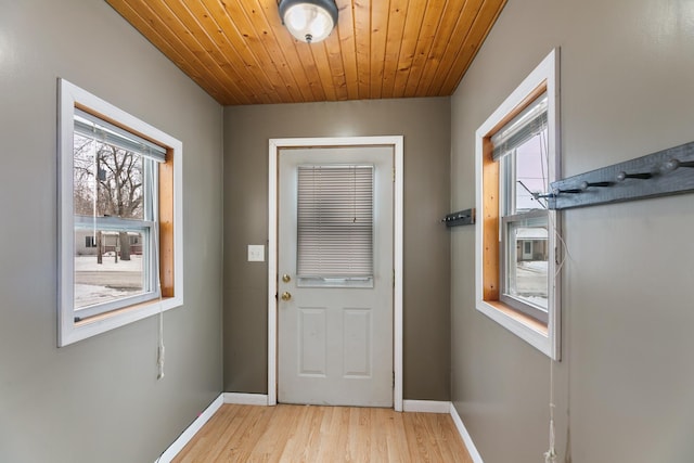 entryway featuring light wood finished floors, wood ceiling, and baseboards