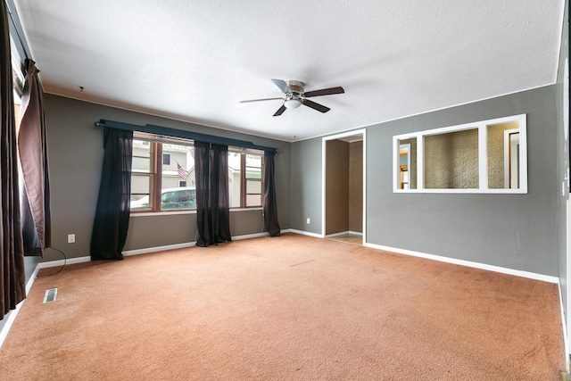 unfurnished room with visible vents, light carpet, ceiling fan, a textured ceiling, and baseboards