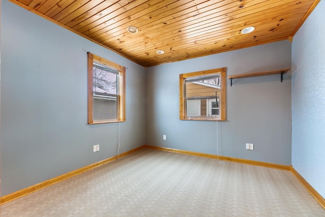 carpeted empty room with wood ceiling and baseboards