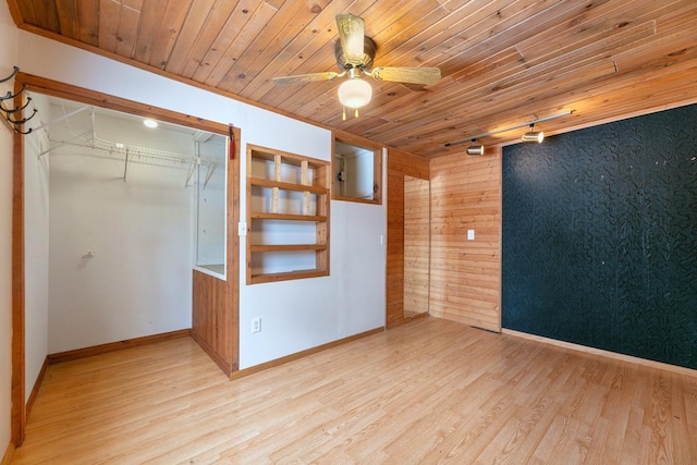 interior space with a closet, wooden ceiling, light wood-style flooring, and baseboards