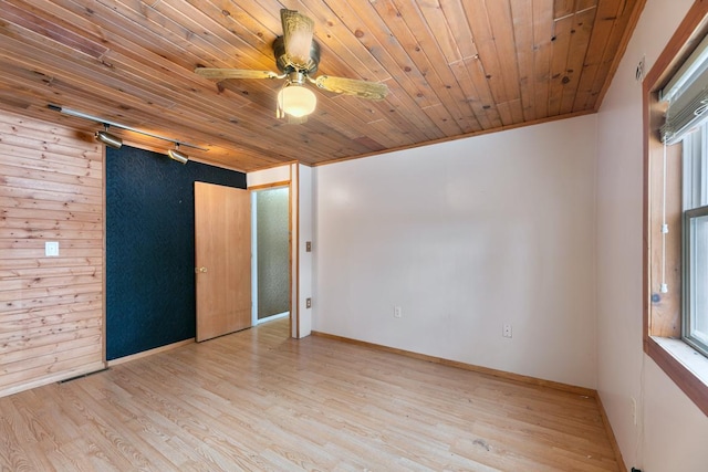 empty room featuring a ceiling fan, light wood-type flooring, wood ceiling, and a healthy amount of sunlight