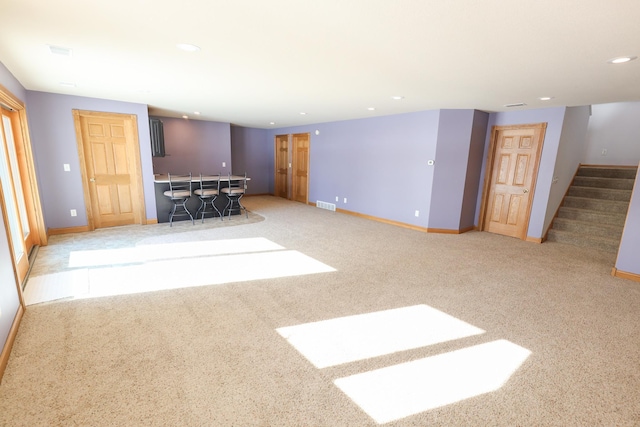 unfurnished living room featuring light carpet