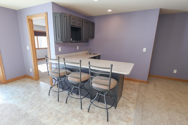 kitchen with a breakfast bar, sink, and kitchen peninsula