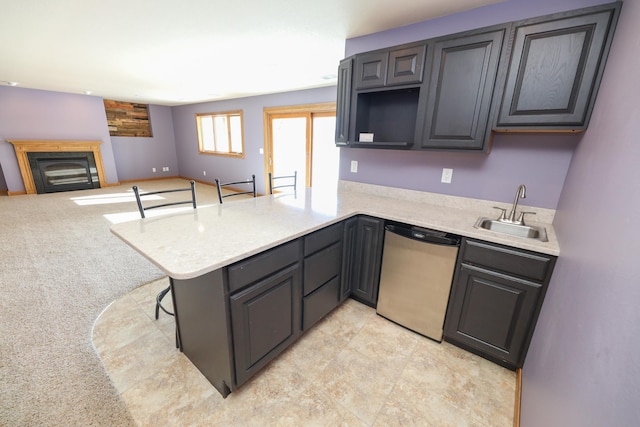 kitchen with stainless steel dishwasher, kitchen peninsula, and sink
