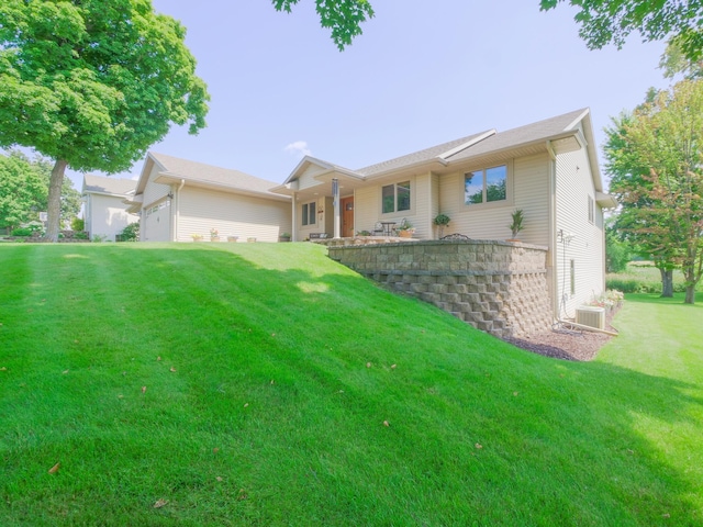 ranch-style house featuring a garage, central AC unit, and a front yard