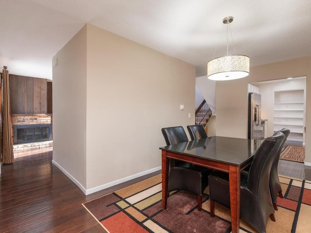 home office with a fireplace, dark wood-type flooring, and built in features