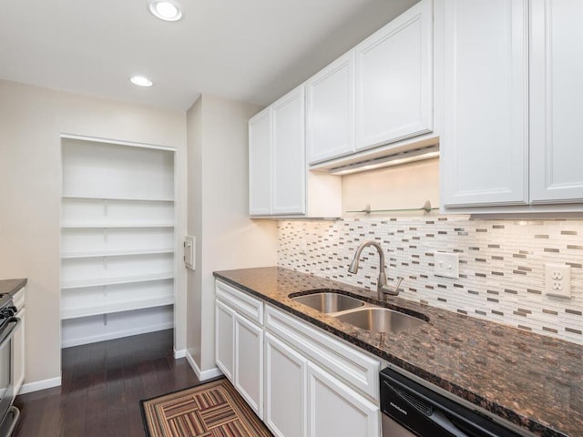 kitchen featuring sink, white cabinetry, dishwashing machine, and dark stone countertops