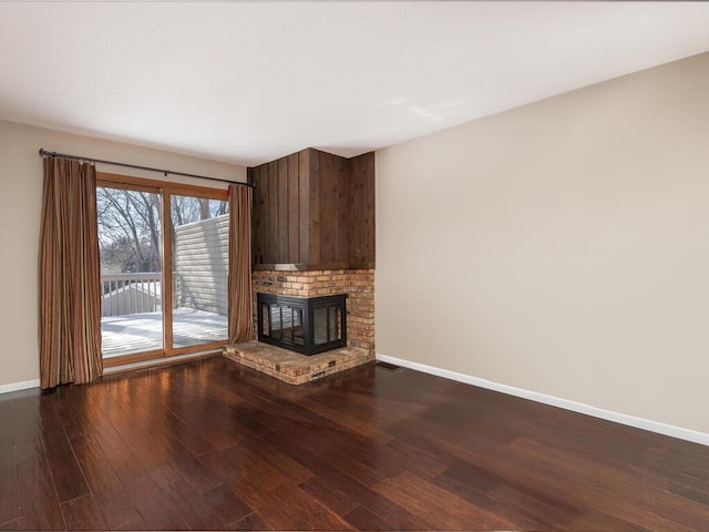 unfurnished living room with a fireplace and dark wood-type flooring