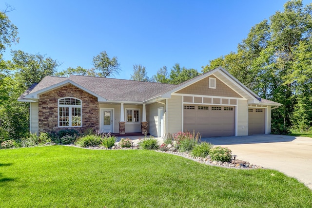 view of front of home with a front yard, roof with shingles, concrete driveway, stone siding, and a garage