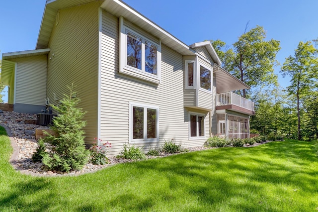 back of property with a balcony and a yard