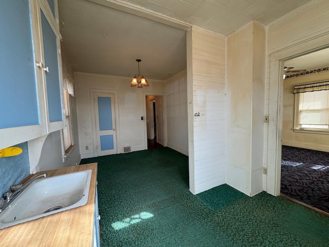 interior space with a chandelier, carpet, visible vents, and a sink