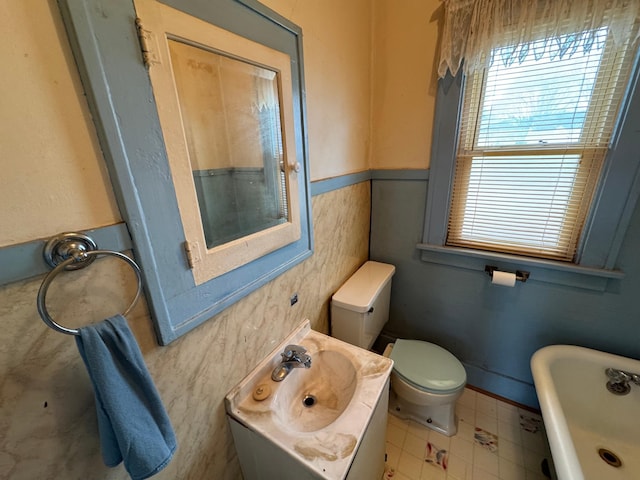 full bath with toilet, a soaking tub, vanity, and tile patterned floors