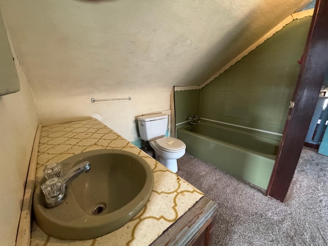 bathroom with a garden tub, toilet, vaulted ceiling, vanity, and a textured ceiling