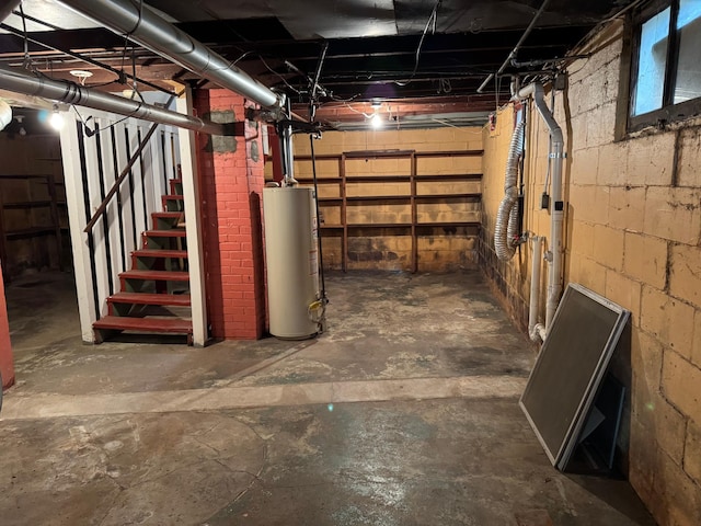 unfinished basement with water heater and stairway