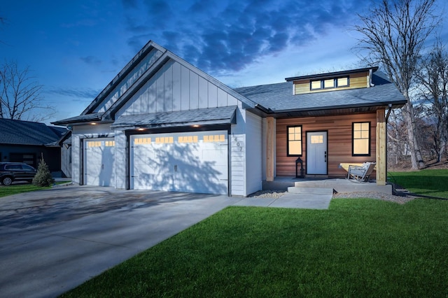 view of front of property featuring a garage, a yard, and covered porch