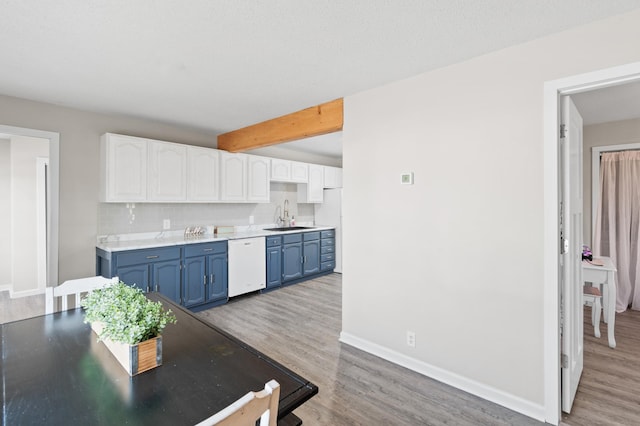 kitchen featuring blue cabinetry, white appliances, white cabinetry, and a sink