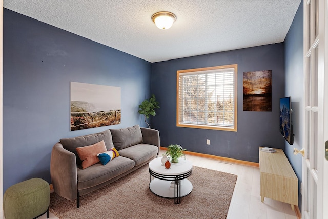 living room with light hardwood / wood-style flooring and a textured ceiling