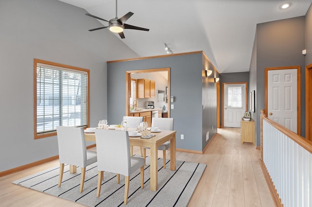 dining room with vaulted ceiling, sink, and light hardwood / wood-style floors