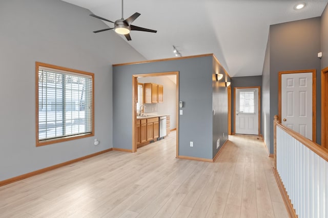 empty room featuring sink, light hardwood / wood-style flooring, ceiling fan, and vaulted ceiling