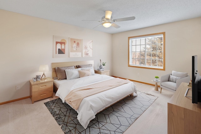 bedroom featuring ceiling fan, carpet floors, and a textured ceiling