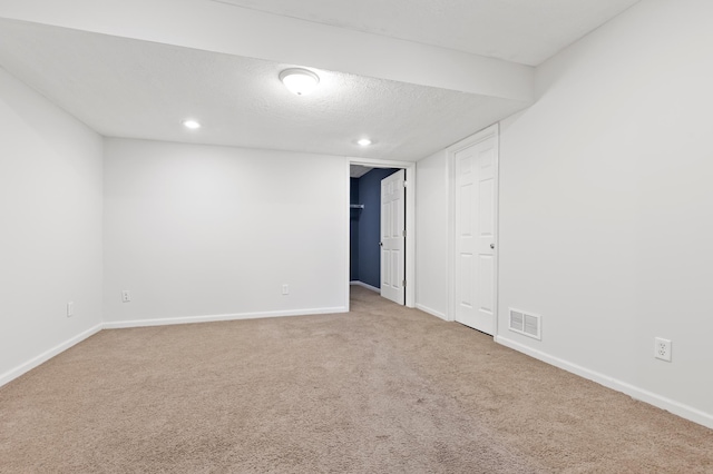 spare room with a textured ceiling and carpet flooring