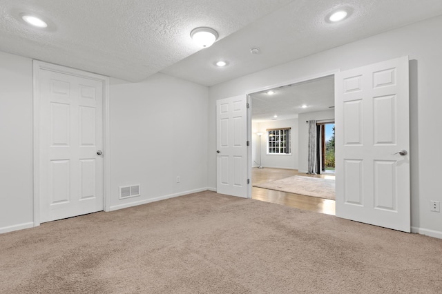 empty room with carpet flooring and a textured ceiling