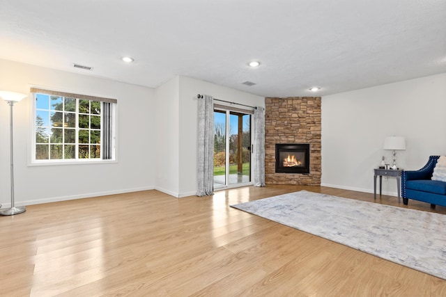 unfurnished living room with a wealth of natural light, a fireplace, and light hardwood / wood-style flooring