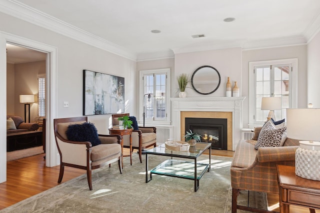 living area with hardwood / wood-style floors and ornamental molding