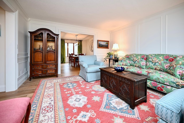 living room with crown molding and light hardwood / wood-style flooring