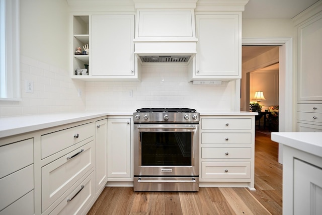 kitchen with white cabinets, light wood-type flooring, and stainless steel gas stove