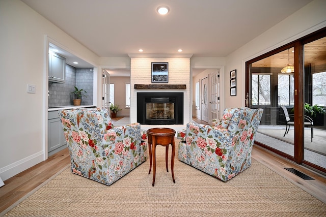 living room featuring plenty of natural light, a fireplace, and light hardwood / wood-style flooring