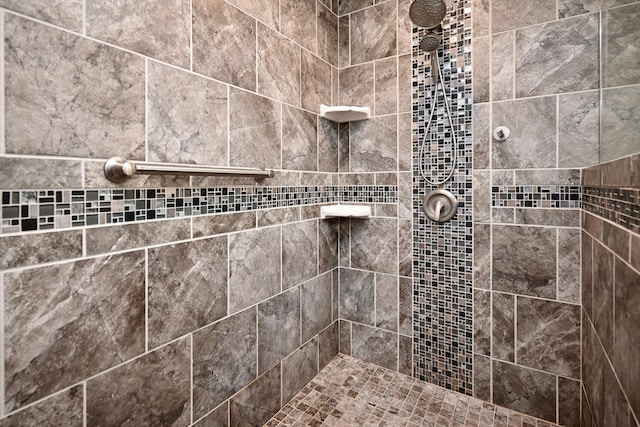 interior details featuring tiled shower