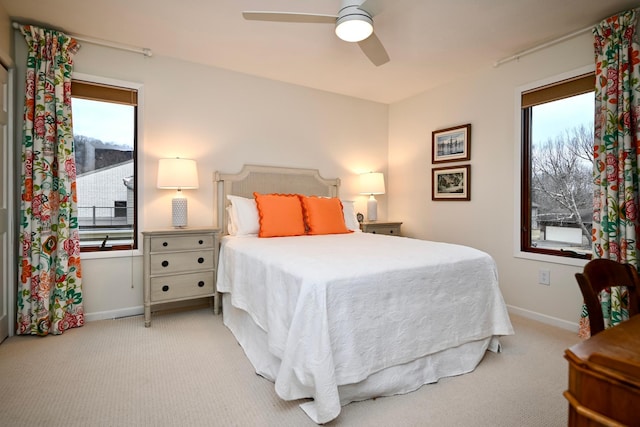 carpeted bedroom featuring multiple windows and ceiling fan