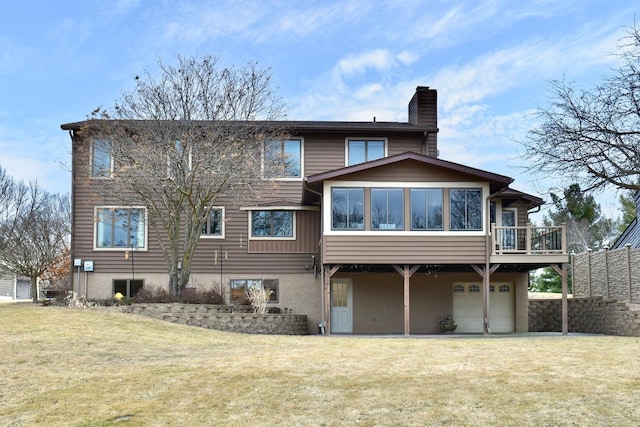 rear view of property featuring a wooden deck, a yard, and a garage