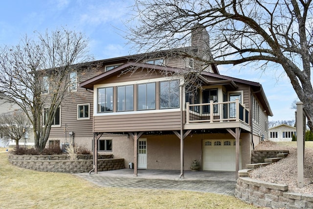 back of house with a garage and a lawn