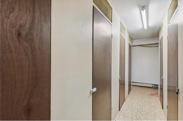 hall with a baseboard heating unit and a textured ceiling