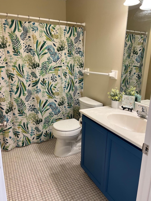 bathroom featuring toilet, tile patterned flooring, and vanity