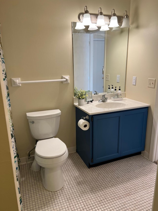 bathroom featuring tile patterned flooring, baseboards, vanity, and toilet