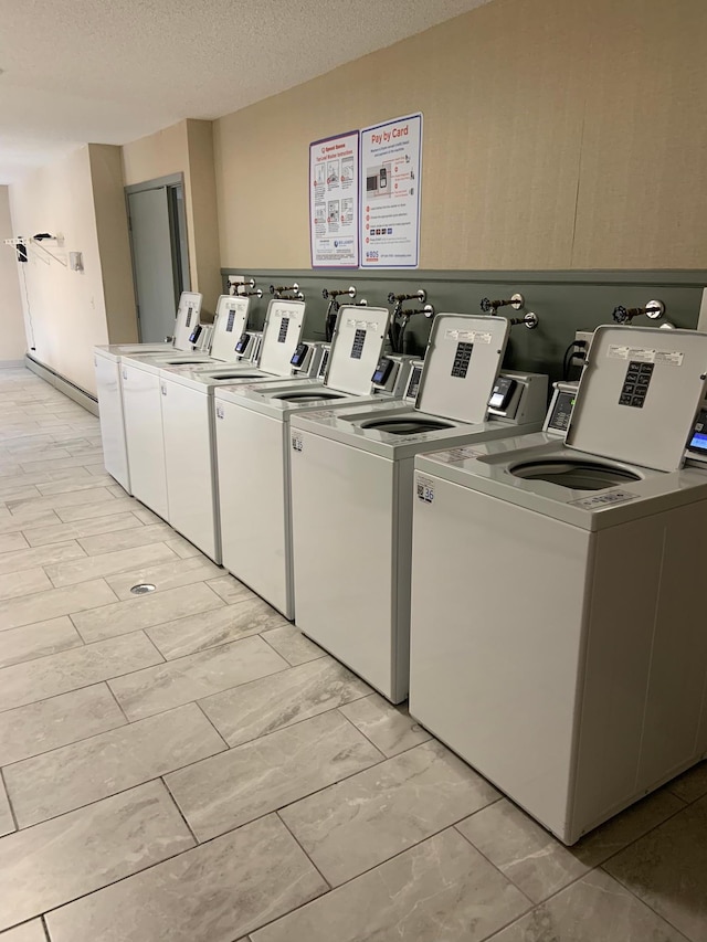 shared laundry area featuring a textured ceiling and washer and clothes dryer