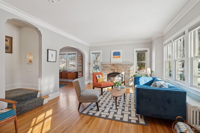 interior space featuring radiator, plenty of natural light, wood finished floors, and a glass covered fireplace