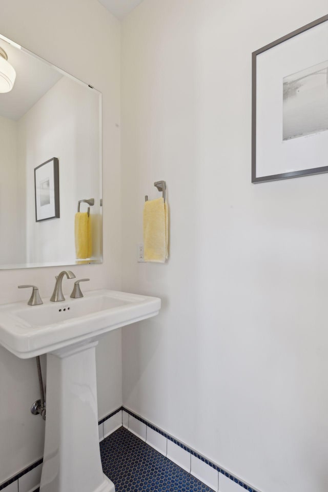 bathroom featuring tile patterned flooring, baseboards, baseboard heating, and a sink